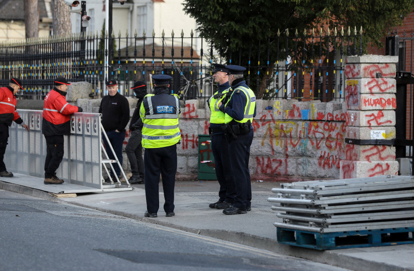  Gardai (Irish Police) watch as workers assemble security barriers at the Russian Embassy, following an incident where a truck reversed through the entrance gate to the embassy, in Dublin, Ireland March 7, 2022 (credit: REUTERS/LORRAINE O'SULLIVAN)