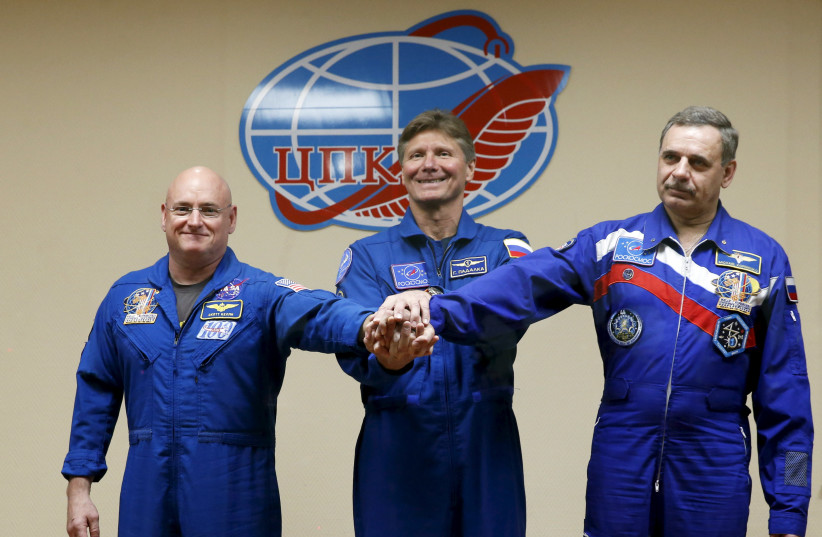  (From L to R) NASA astronaut Scott Kelly, Russian cosmonauts Gennady Padalka and Mikhail Kornienko, members of the 43 International Space Station crew, pose during a news conference behind a glass wall at Baikonur cosmodrome March 26, 2015 (credit: MAXIM ZMEYEV/REUTERS)