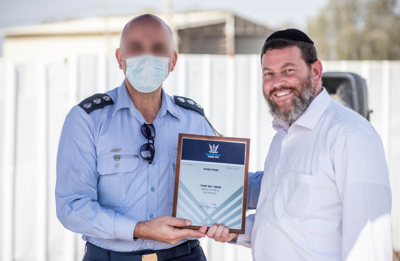 A rabbi from Netzah Yehuda is seen receiving a certificate of appreciation from the IAF. (credit: Roei Kor)
