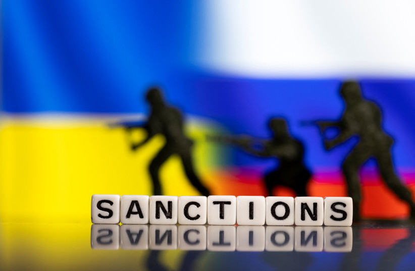  Plastic letters arranged to read ''Sanctions'' and solider toys are placed in front of Ukraine's and Russia's flag colors in this illustration taken February 25, 2022. (credit: REUTERS/DADO RUVIC/ILLUSTRATION)
