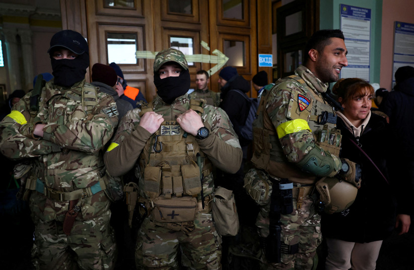  Ben Grant and other foreign fighters from the UK pose for a picture as they are ready to depart towards the front line in the east of Ukraine following the Russian invasion, at the main train station in Lviv, Ukraine, March 5, 2022. (photo credit: KAI PFAFFENBACH/REUTERS)