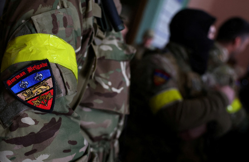 A badge is pictured on a uniform of a foreign fighter from the UK as they are ready to depart towards the front line in the east of Ukraine following the Russian invasion, at the main train station in Lviv, Ukraine, March 5, 2022. (photo credit: KAI PFAFFENBACH/REUTERS)