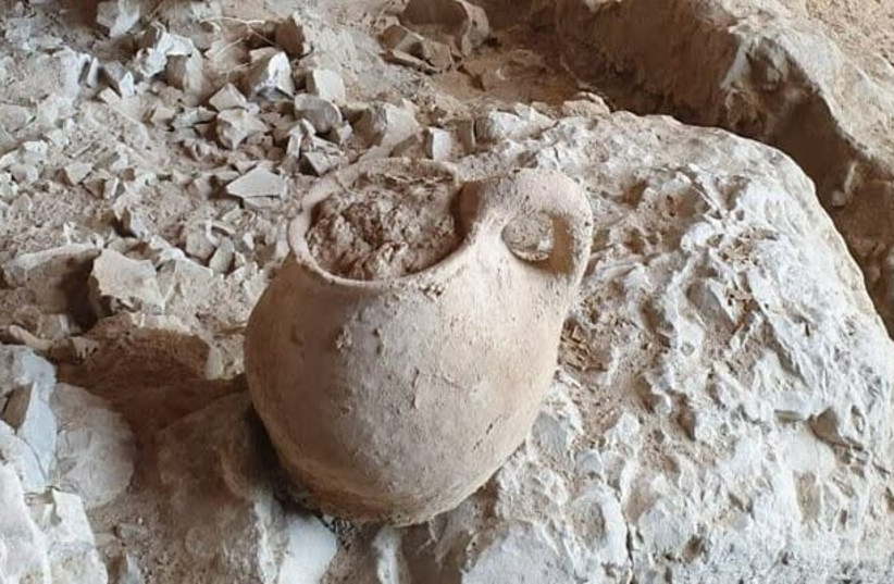  Ancient clay jug discovered in cave 53 of Qumran, Feb. 2022. (photo credit: Amir Ganor/Israel Antiquities Authority)