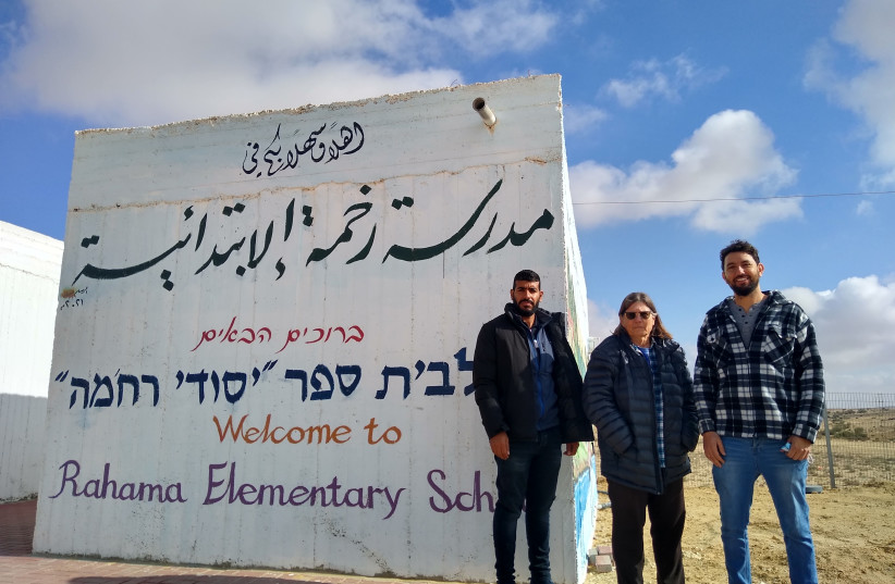  (FROM L) Vice Principal Zaher Abuzar, activist Yael Agmon and youth center co-manager Neta Tsahor in front of Rahme Elementary School’s painted sign. (photo credit: Anav Silverman-Peretz)