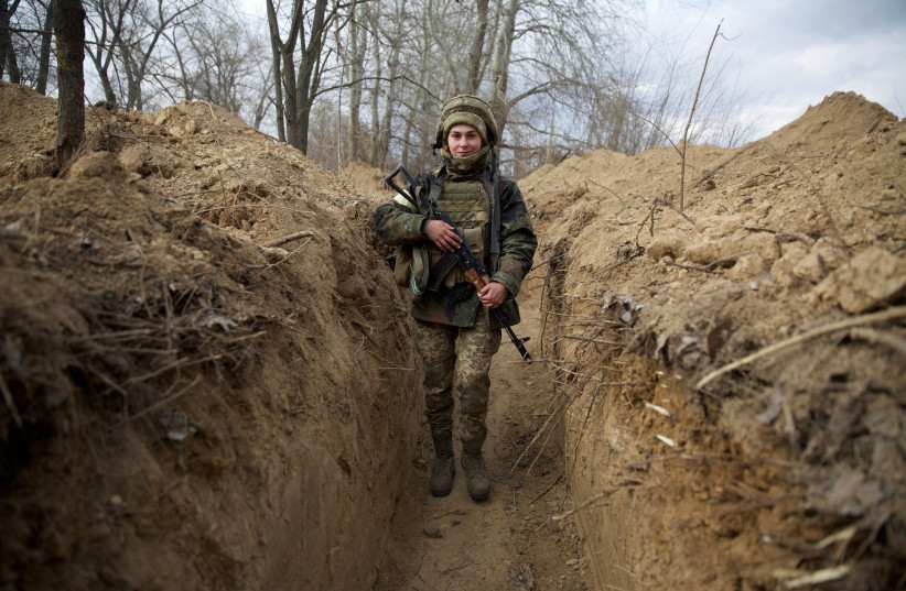  A member of the Ukrainian military walks, amid Russia's invasion in Ukraine, near Kyiv, Ukraine March 8, 2022. (credit: Anna Kudriavtseva/Reuters)