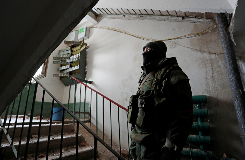  A service member of pro-Russian troops stands inside a residential building in Volnovakha (photo credit: REUTERS)
