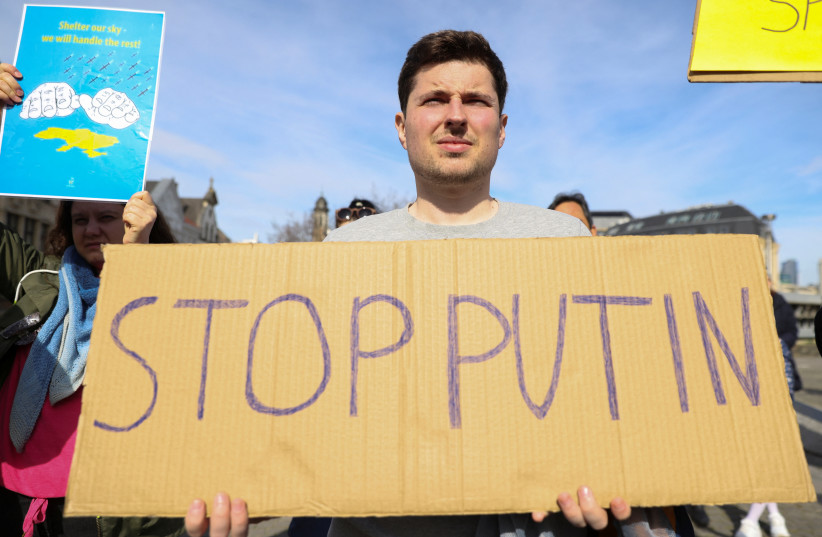 A man holds a sign during a protest in support of Ukraine after Russia's invasion, in Brussels, Belgium, March 13, 2022. (credit: JOHANNA GERON/REUTERS)