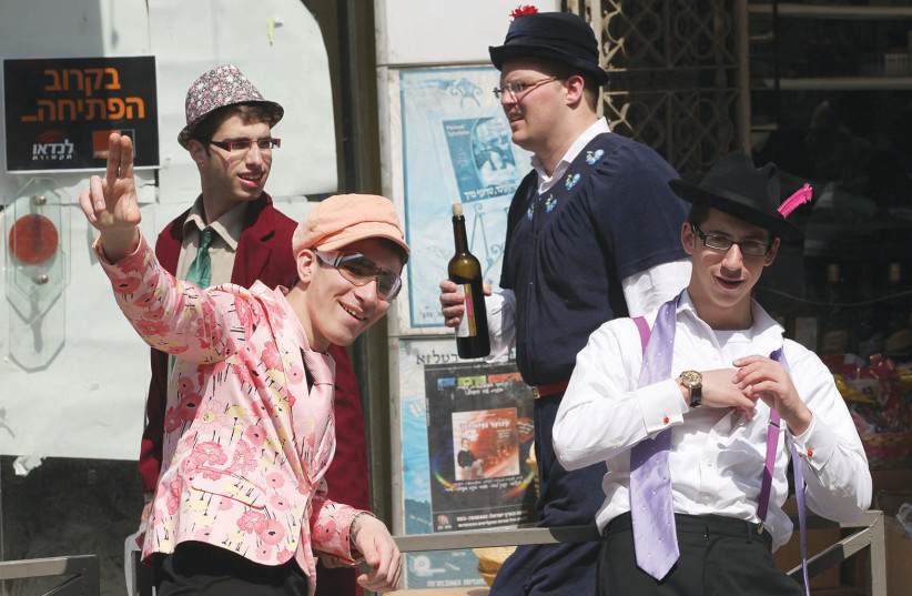  YOUNG MEN celebrate Purim in Jerusalem in costume and with drink. (credit: NATI SHOHAT/FLASH90)