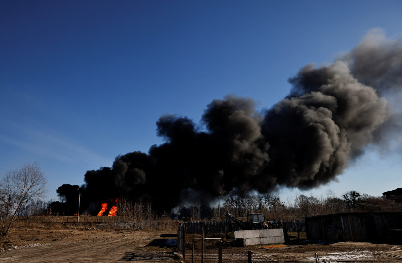  A column of smoke rises from burning fuel tanks that locals said were hit by five rockets at the Vasylkiv Air Base, following Russia's invasion of Ukraine, outside Kyiv, Ukraine, March 12, 2022.  (photo credit: THOMAS PETER/REUTERS)