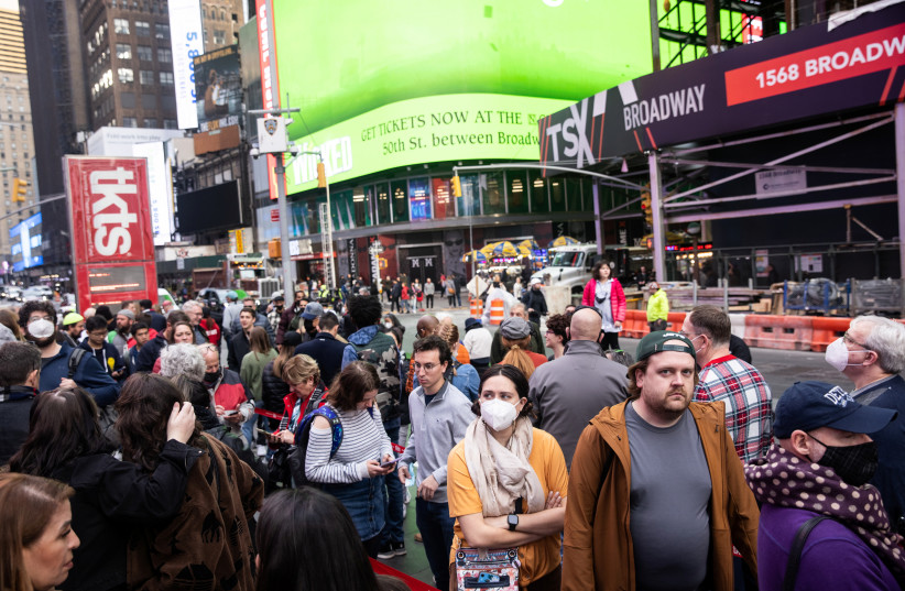 People wait in line for the TKTS box office for Broadway and off-Broadway shows in Times Square in New York City, US, December 16, 2021. (credit: REUTERS/JEENAH MOON)