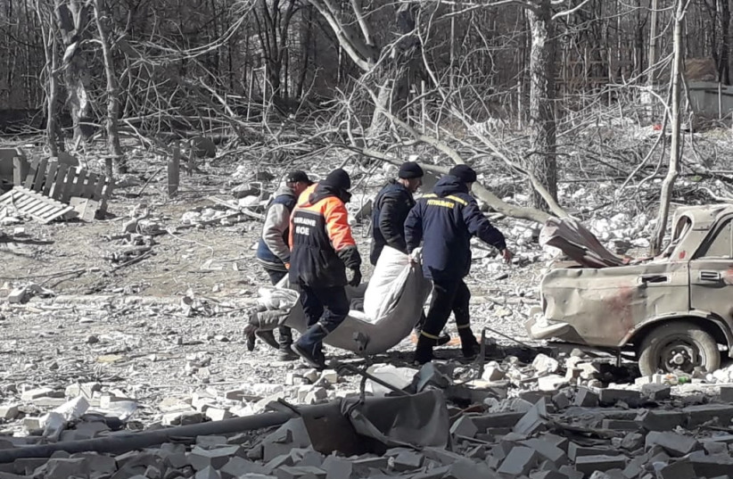  Rescuers carry the body of a person who was killed by shelling, as Russia's attack on Ukraine continues, in Chernihiv, Ukraine, in this handout picture released March 17, 2022.  (photo credit: Press service of the Ukrainian State Emergency Service/Handout via REUTERS)