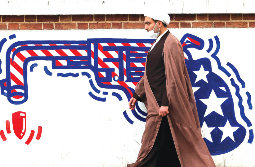  AN IRANIAN cleric walks past an anti-US mural on a wall of the former American Embassy in Tehran this week. (photo credit: Atta Kenare/AFP via Getty Images)