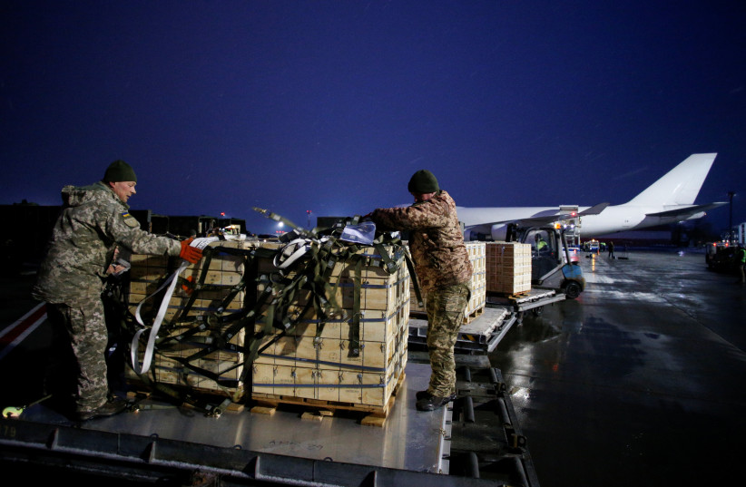 Ukrainian service members unload a shipment of military aid, delivered as part of the United States' security assistance to Ukraine, at the Boryspil International Airport outside Kyiv, Ukraine, February 5, 2022. (photo credit: REUTERS/VALENTYN OGIRENKO)
