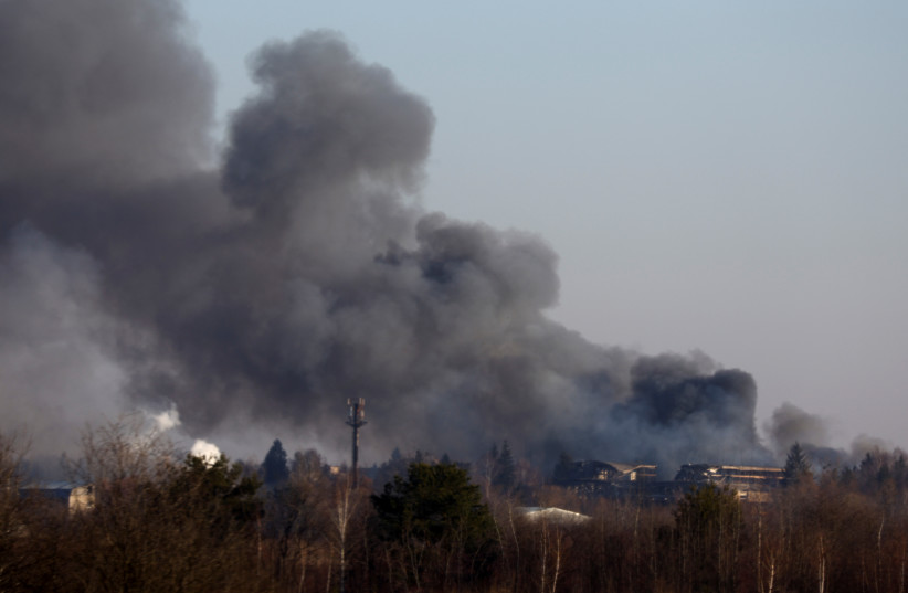  Smoke rises from a factory building near Lviv airport, as Russia's invasion of Ukraine continues, in Lviv, Ukraine, March 18, 2022.  (photo credit: KAI PFAFFENBACH/REUTERS)