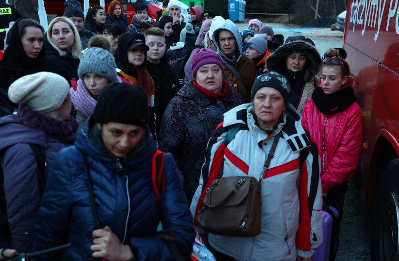  Refugees from Ukraine wait to board a bus to Warsaw after crossing the border from Ukraine to Poland, fleeing the Russian invasion of Ukraine, at border checkpoint in Kroscienko, Poland, March 17, 2022. (photo credit: REUTERS/FABRIZIO BENSCH)