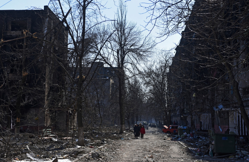  Local residents walk near residential buildings which were damaged during Ukraine-Russia conflict in the besieged southern port city of Mariupol, Ukraine March 18, 2022. (photo credit: REUTERS/STRINGER)