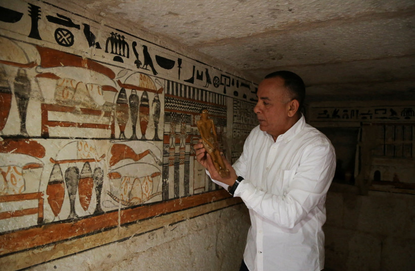  Secretary-General of the Supreme Council of Antiquities, Mostafa Waziri,displays a small statue at a recently discovered tomb at the Saqqara area, in Giza. (photo credit: REUTERS/HANAA HABIB)