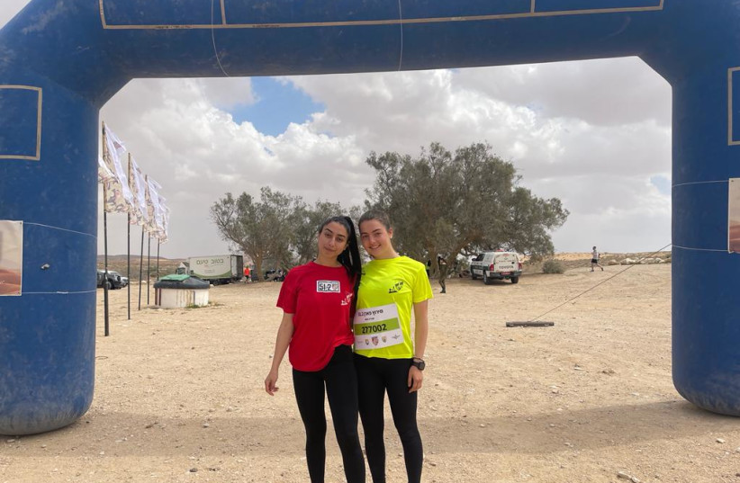  Sgt. Daniela David (in red), originally from London, and Sgt. Eliya Shor pose during a 51.2 km relay race on March 23, 2022.  (credit: IDF SPOKESPERSON'S UNIT)
