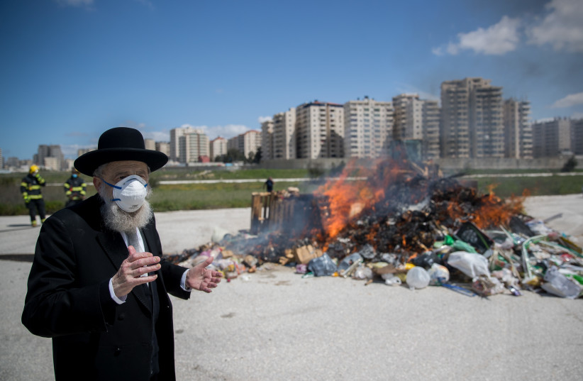  BURNING CHAMETZ collected by the Jerusalem Municipality, with the city’s Chief Ashkenazi Rabbi Aryeh Stern in attendance, April 2020.  (credit: YONATAN SINDEL/FLASH90)