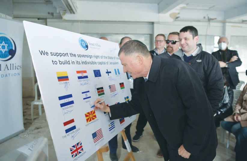  MEMBERS OF the Israel Allies Foundation put their signatures beneath the flags of their respective countries. In the foreground is Likud MK Yuli Edelstein signing beneath the Israeli flag.  (photo credit: AVI HAYOUN)