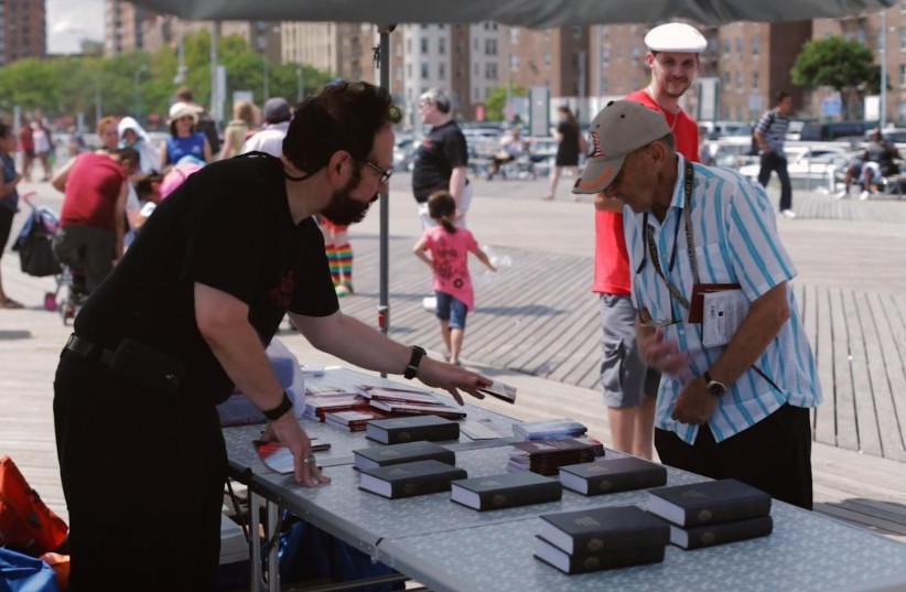 A member of Chosen People Ministries hands out bibles in New York City. (photo credit: YOUTUBE)