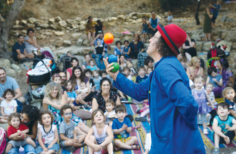  CHILDREN AND ADULTS are entertained in Kiryat Hayovel, as part of the ‘Let’s meet in the park’ project (photo credit: MASHU MASHU THEATER GROUP)