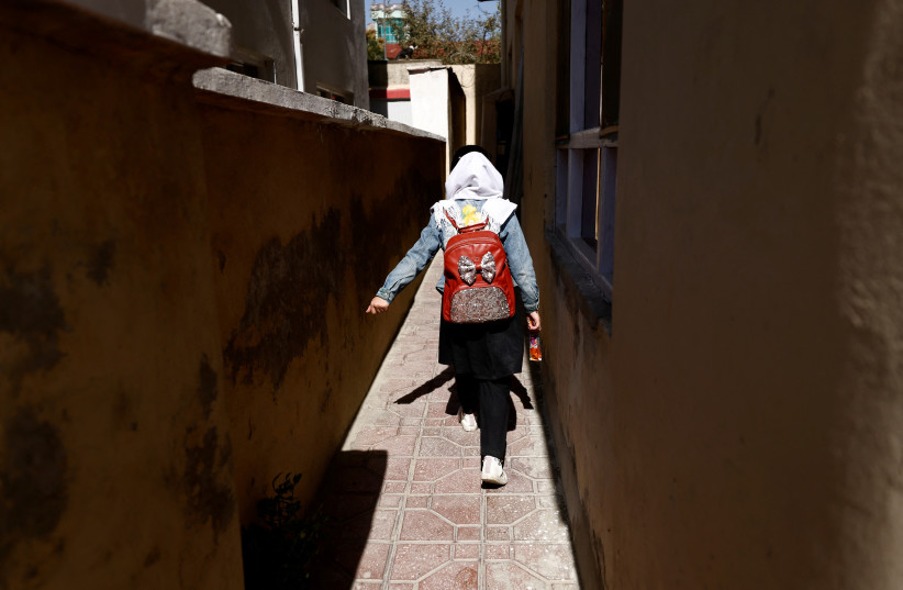 A 4th grade primary school student, walks back from school through an alleyway near her home in Kabul, Afghanistan, October 20, 2021. (credit: REUTERS/ZOHRA BENSEMRA)