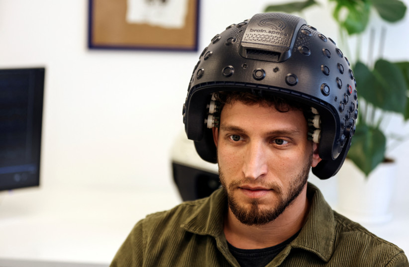  A worker at the Israeli startup Brain.Space demonstrates an electroencephalogram (EEG) enabled helmet, due to be used in an experiment on the impact of a microgravity environment on the brain activity of astronauts, in Tel Aviv, Israel, March 23, 2022. (credit: REUTERS/NIR ELIAS)