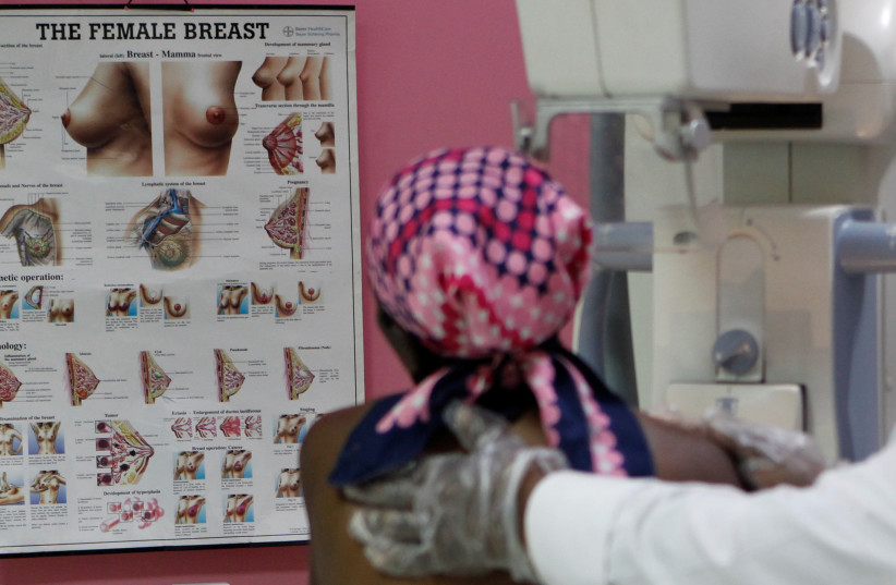 A patient looks at a chart as she prepares to undergo a mammogram X-ray picture of the breast to look for early signs of breast cancer in the radiology unit at the Kenyatta National Hospital in Nairobi, Kenya January 23, 2020. (credit: REUTERS/NJERI MWANGI)