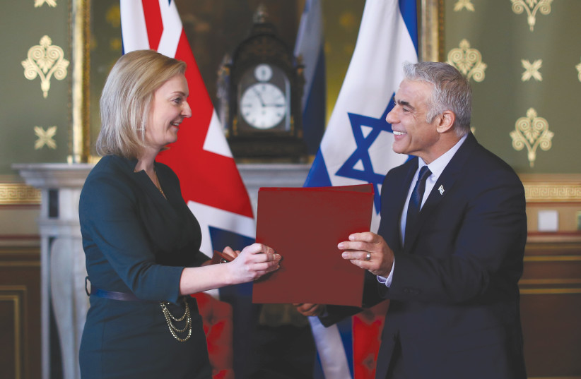 FOREIGN MINISTER Yair Lapid and Britain’s Foreign Secretary Liz Truss exchange documents after signing a memorandum of understanding at the Foreign, Commonwealth & Development Office in London, in November. (photo credit: Hannah McKay/Reuters)