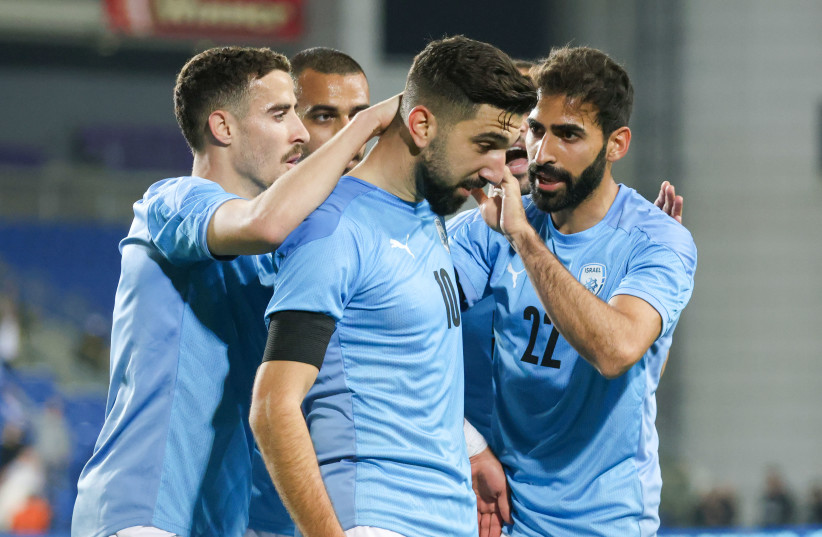 MONAS DABBUR (center) is congratulated by his teammates after he scored two goals in the second half to help Israel earn a 2-2 draw with Romania in Tuesday's international friendly at Netanya Stadium. (photo credit: DANNY MARON)