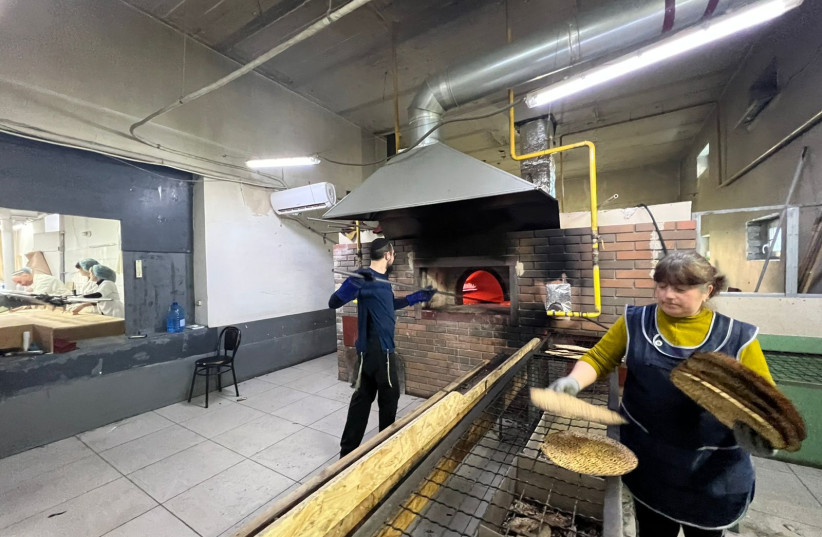  A factory worker makes shmura matzah under supervision in Ukraine. (credit: MEYER STAMBLER)