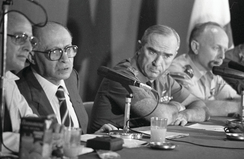  PRIME MINISTER Menachem Begin holds a special press conference to announce the Osirak reactor bombing, June 9, 1981. Also present: Uri Porat, PM media adviser (L) and IDF Chief of Staff Rafael ‘Raful’ Eitan (R).  (credit: NATIONAL LIBRARY OF ISRAEL)