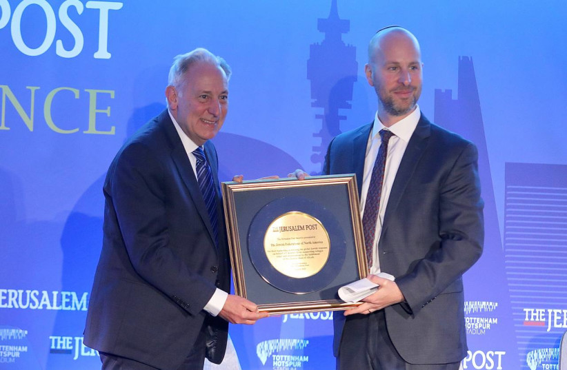 JFNA CEO Eric Fingerhut (L) is seen being awarded the Jerusalem Post leadership award by editor-in-chief Yaakov Katz at the London Conference, on March 31, 2022. (photo credit: MARC ISRAEL SELLEM/THE JERUSALEM POST)