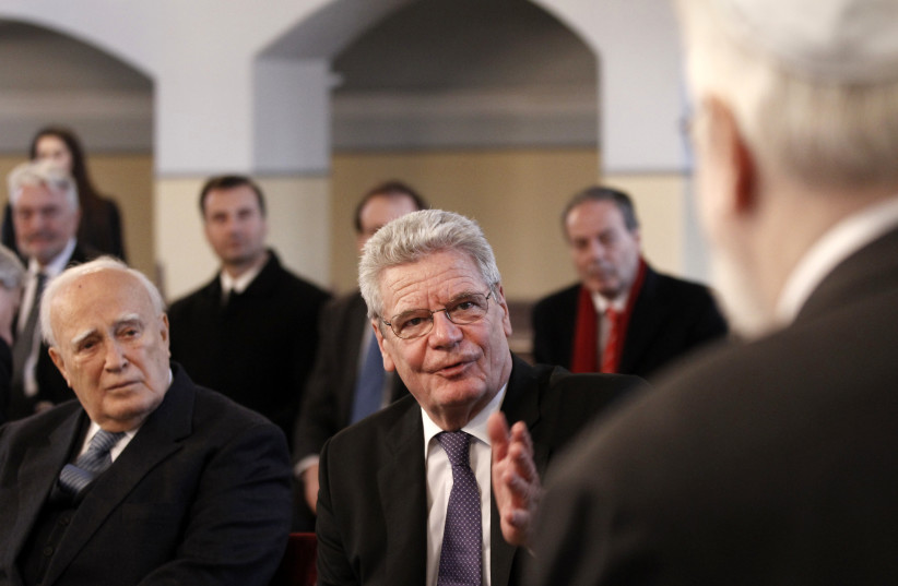  GERMAN THEN-PRESIDENT Joachim Gauck (C) speaks to the head of the Greek-Jewish community of Ioannina during his 2014 visit to their synagogue in northwestern Greece, as tribute to the dozens massacred by the Nazis.  (photo credit: Alkis Konstantinidis/Reuters)