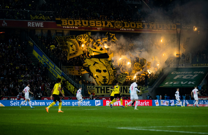  Borussia Dortmund fans burn pyrotechnics at a game in Cologne, March 20, 2022. (photo credit: Rolf Vennenbernd/picture alliance via Getty Images)