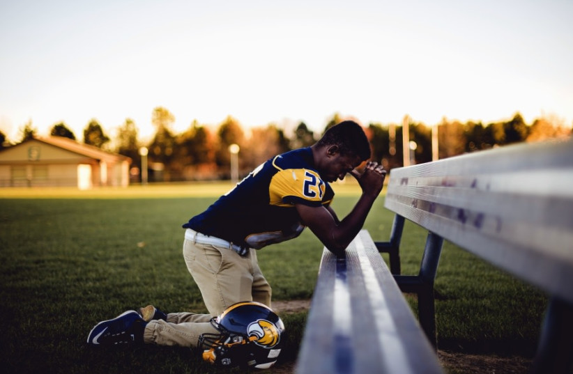  Sports player prayers after a game (photo credit: PIXNIO)