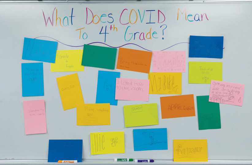  A FOURTH GRADE teacher in Allentown, Pennsylvania, has students write what COVID-19 means to them as a way of grappling with mental health challenges.  (photo credit: Hannah Beier/Reuters)