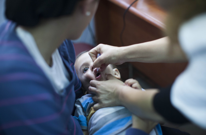  An child is vaccinated at a Children's Medical Center in Neve Yaakov, Jerusalem, 10 September 2013. (photo credit: YONATAN SINDEL/FLASH90)