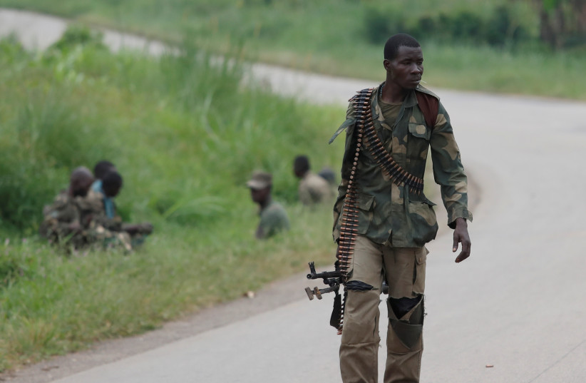  An Armed Forces of the Democratic Republic of the Congo (FARDC) soldier walks along a road after Islamist rebel group called the Allied Democratic Forces (ADF) attacked area around Mukoko village, North Kivu province of Democratic Republic of Congo, December 11, 2018.  (photo credit: REUTERS/GORAN TOMASEVIC)