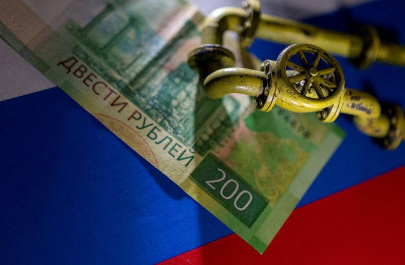  A model of the natural gas pipeline is placed on Russian Rouble banknote and a flag in this illustration taken, March 23, 2022. (photo credit: REUTERS/DADO RUVIC/ILLUSTRATION/FILE PHOTO)