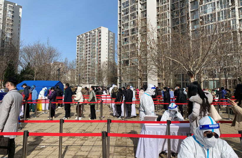  Residents line up during a mass testing for the coronavirus disease (COVID-19), at a makeshift nucleic acid testing site in a residential compound in Beijing, China March 21, 2022. (photo credit: REUTERS/XIAOYU YIN)