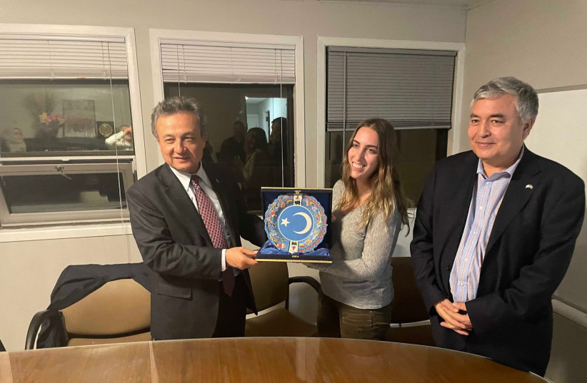  Teich (center) receiving a gift of appreciation from the World Uyghur Congress president Dolkun Isa (left) and Uyghur Rights Advocacy Project Executive Director Mehmet Tohti (right) (photo credit: Sarah Teich)