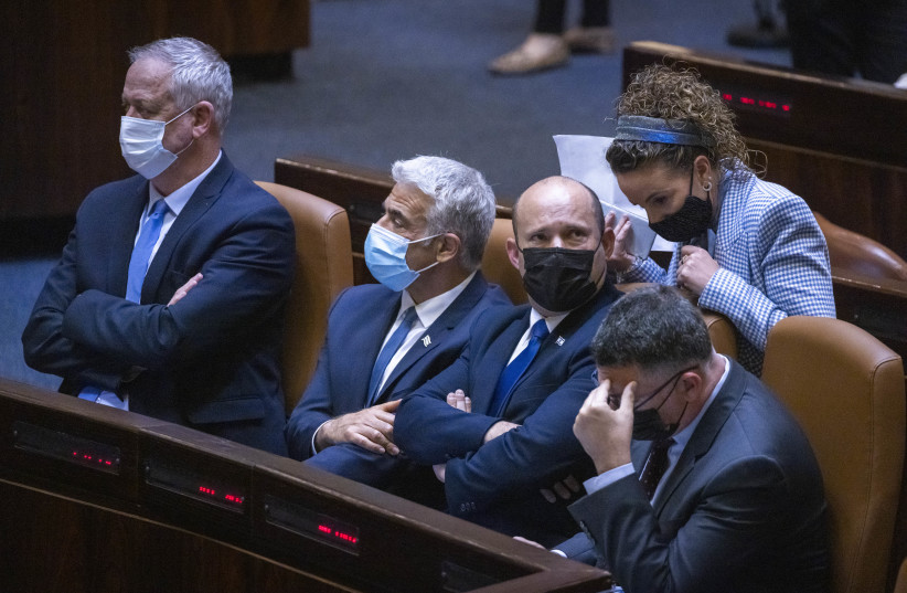  Israeli Defense Minister Benny Gantz, Israeli Foreign Minister Yair Lapid with Prime Minister Naftali Bennet and Idit Silman attend a plenary session at the assembly of the Knesset, the Israeli Parliament in Jerusalem, June 28, 2021 (credit: OLIVIER FITOUSSI/FLASH90)