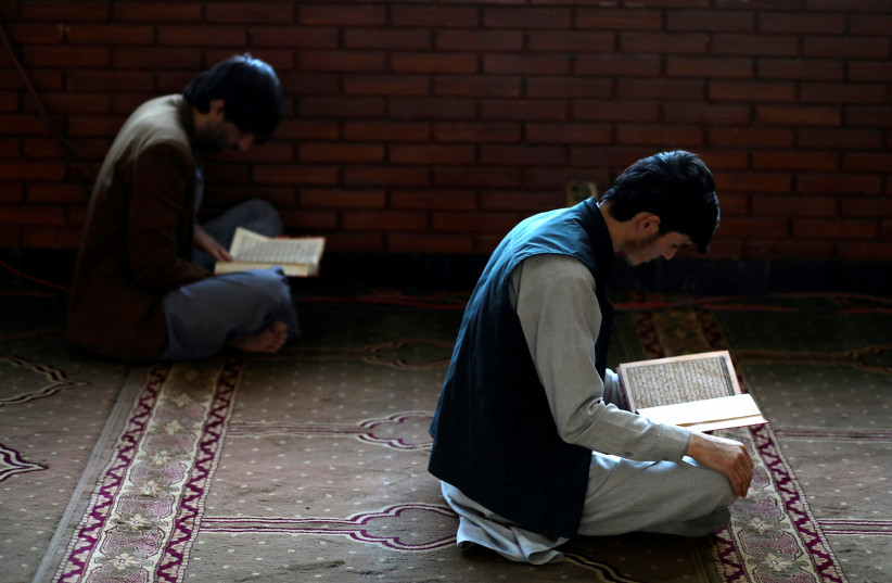  Afghan men read the Koran at a mosque during the holy month of Ramadan in Kabul, Afghanistan, April 5, 2022. (photo credit:  REUTERS/ALI KHARA)