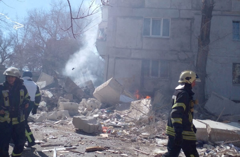  Firefighters walk next to a damaged five-storey building after shelling in the city of Sievierodonetsk, Luhansk region, Ukraine, in this handout photo released on March 28, 2022. (photo credit: State Emergency Service of Ukraine/Handout via REUTERS)