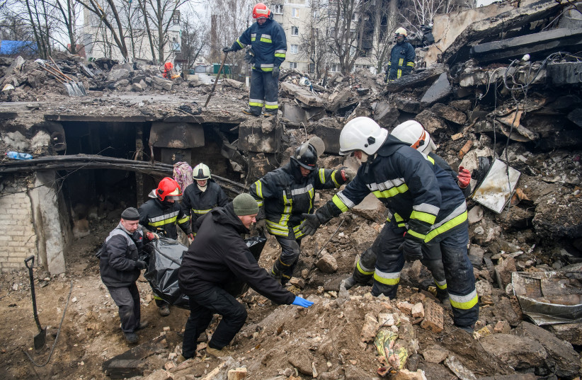  Rescuers carry a body of a person found under debris of a residential building destroyed during Russia's invasion in the town of Borodyanka, Kyiv region, Ukraine April 9, 2022. (photo credit: REUTERS/VLADYSLAV MUSIIENKO)