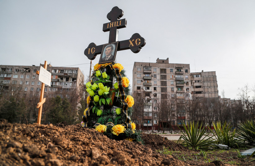  Graves of civilians killed during Ukraine-Russia conflict are seen next to apartment buildings in the southern port city of Mariupol, Ukraine April 10, 2022. (photo credit: REUTERS/ALEXANDER ERMOCHENKO)