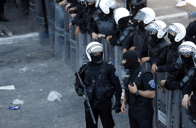  Palestinian police officers stand guard during a protest over the death of Nizar Banat, a critic of the Palestinian Authority, in Ramallah in the West Bank, June 26, 2021 (credit: REUTERS/MOHAMAD TOROKMAN)