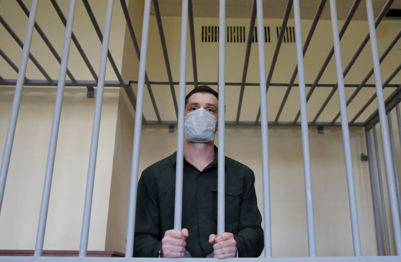 Former US Marine Trevor Reed, who was detained in 2019 and accused of assaulting police officers, stands inside a defendants' cage during a court hearing in Moscow, Russia July 30, 2020. (credit: REUTERS/Maxim Shemetov/File Photo)
